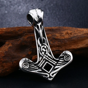 Detailed close-up of a Viking Mjolnir pendant featuring an intricate raven head design