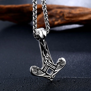 Detailed view of Viking Mjölnir pendant with raven skull design on rustic chain