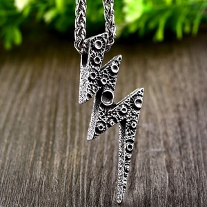 Macro detail of lightning bolt pendant featuring rugged texture and vintage steel chain
