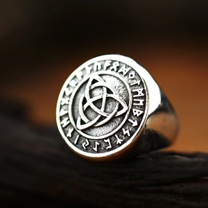 Vintage Celtic Triquetra knot ring with Nordic runes on oxidized stainless steel surface