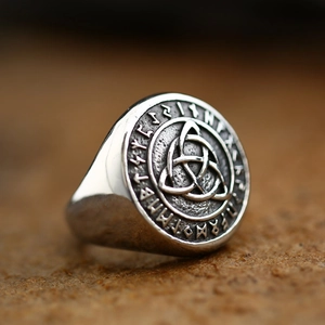 Macro side view of vintage Viking ring with Celtic knot and Nordic runes in aged steel finish