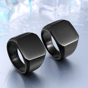 Macro shot of men's matte black signet ring with brushed metal texture and industrial style