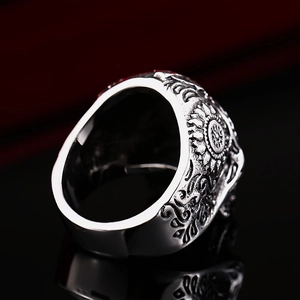 Macro view of vintage stainless steel ring showing intricate floral carving and inner band