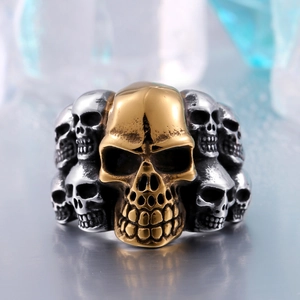Gros plan d'une bague tête de mort bicolore style punk avec détails or et argent