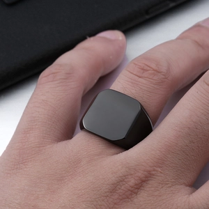 Minimalist men's black matte stainless steel signet ring on finger for modern fashion look