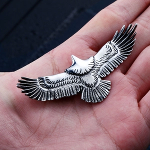 Macro detail of retro stainless steel eagle pendant showing intricate wing feather textures