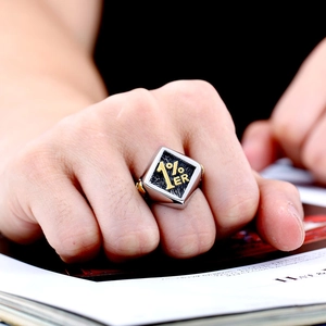 Detailed close-up of a vintage men's stainless steel signet ring with 1% ER gold engraving