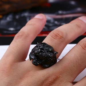 Detail of matte black tiger head ring showing intricate 3D punk style carvings