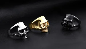 Detailed close-up of punk skull rings in silver, gold, and black plated finishes