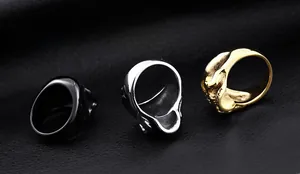 Detailed view of three vintage punk skull rings in black, silver, and gold on leather