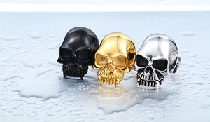 Close-up of gothic skull rings in matte black, polished gold, and vintage silver steel