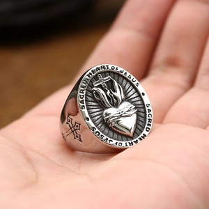 Detailed macro of vintage stainless steel Sacred Heart of Jesus ring with cross engraving