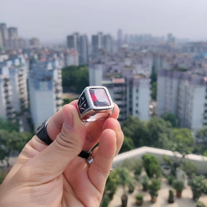 Vue détaillée d'une bague argentée avec une grande pierre rouge et des gravures