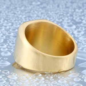 Macro view of gold brushed stainless steel ring on light blue water drop surface