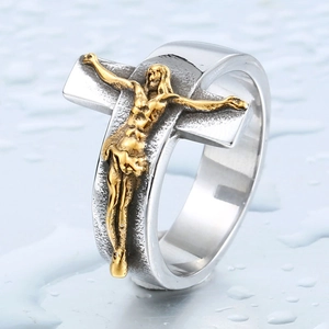 Detail of vintage stainless steel ring featuring a golden crucifix and antique texture