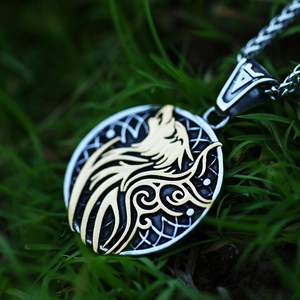 Vintage wolf head pendant in silver and gold tone on a rustic grass background