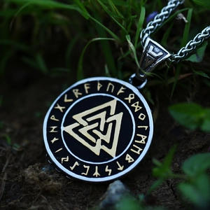 Viking Valknut pendant necklace with Nordic runes on stainless steel chain over grass