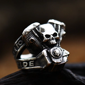 Détail macro d'une bague de motard vintage en acier avec motif crâne et piston de moteur