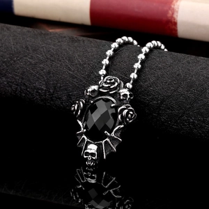 Gothic stainless steel skull and rose pendant necklace with a black faceted gemstone
