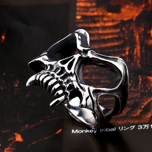 Detail of vintage stainless steel skull ring with gothic mask texture and dark finish