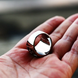 Detailed macro shot of vintage stainless steel biker ring with embossed side patterns