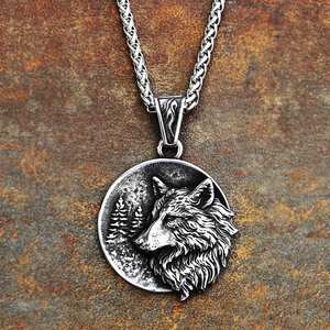 Macro view of vintage stainless steel wolf head pendant with textured pine forest background