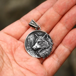 Macro view of a retro wolf head embossed pendant in vintage stainless steel finish