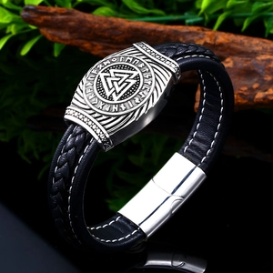 Macro detail of Viking leather bracelet showing Valknut symbol and runic metal plate