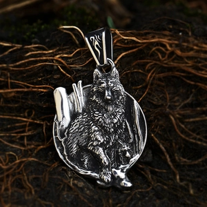 Macro shot of vintage steel wolf head pendant on natural earthy textured background