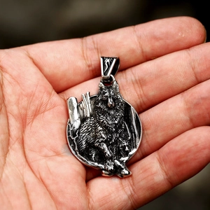 Macro shot of a vintage silver wolf head pendant in palm to show the scale and texture