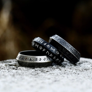 Three Viking stainless steel rune rings with vintage brushed finish on gray stone surface