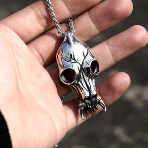 Close-up of vintage stainless steel skull pendant with intricate gothic carvings and cord chain