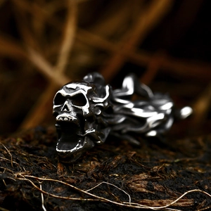 Punk style flaming skull pendant in vintage stainless steel on natural wood background