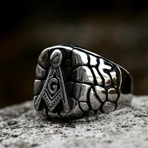Retro stainless steel Freemason ring for men with G symbol on a grey stone surface