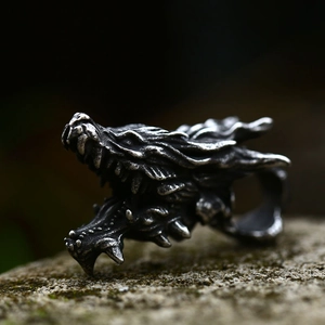 Gothic dragon head ring in vintage stainless steel on a natural mossy stone background