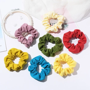 Flat lay of 7-color fabric hair scrunchie set including beige and navy on white background