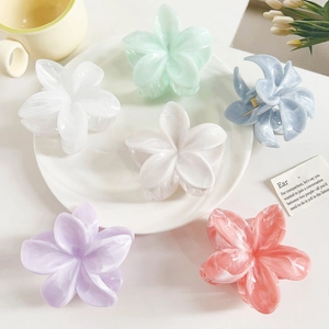 Detail view of five marble-textured frangipani hair claws in various pastel colors