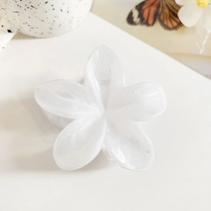 Macro side view of marble white frangipani hair claw clip with smooth acetate finish