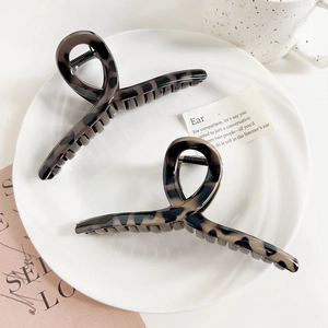 Détail de deux grandes pinces à cheveux léopard sur une assiette en céramique