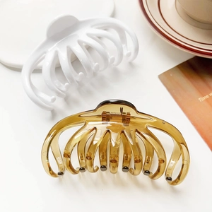Detailed view of large ceramic white and amber pumpkin hair claws set for thick hair