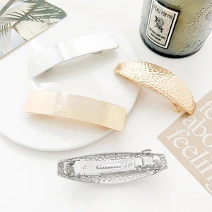 Detail showing the metal spring hair clip texture with vertical and hammered finish surface