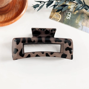 Grande pince à cheveux carrée à motif léopard sur un fond blanc au style minimaliste