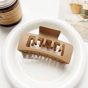 Detailed view of large matte caramel brown square claw clip with double layer hollow design