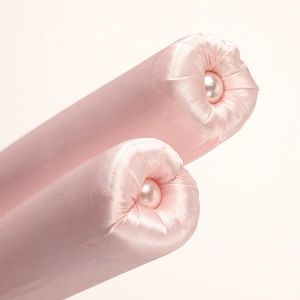 Pink satin heatless hair curler with pearl details for overnight wave styling