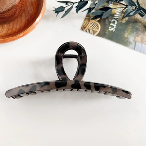 Détail du motif léopard écaille de tortue sombre sur une grande pince à cheveux