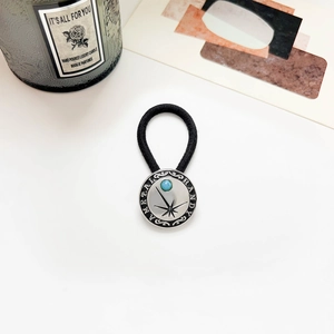 Detail of vintage turquoise turquoise hair tie with silver starburst metal decoration