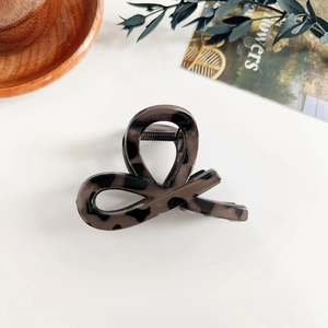 Détail macro de la pince à cheveux en résine gris foncé avec motif léopard brillant
