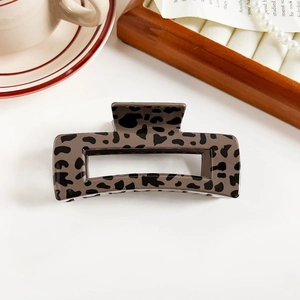 Detailed top view of leopard print hair claw clip among elegant aesthetic props