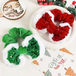 Dettaglio di elastici per capelli natalizi in velluto rosso e verde con paillettes e peluche
