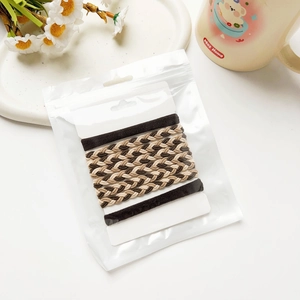 Détail d'élastiques à cheveux marron avec texture tissée et emballage sur support carton